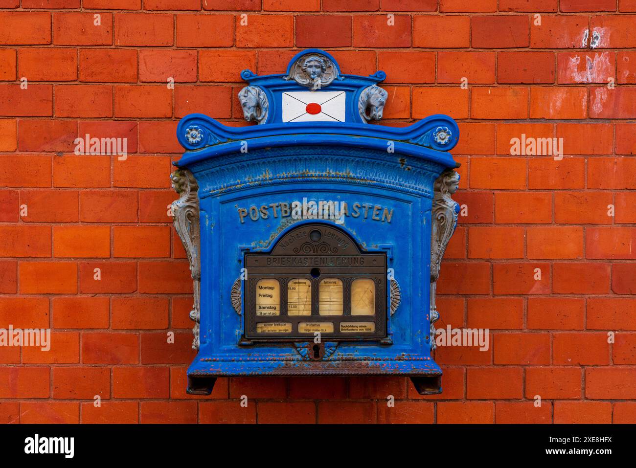 Blue mailbox on red brick wall. Stock Photo