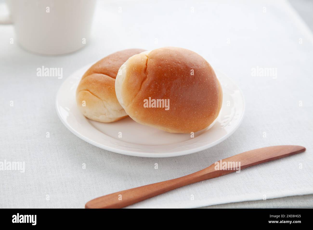 butter bread table rolls on plate isolated on table Stock Photo