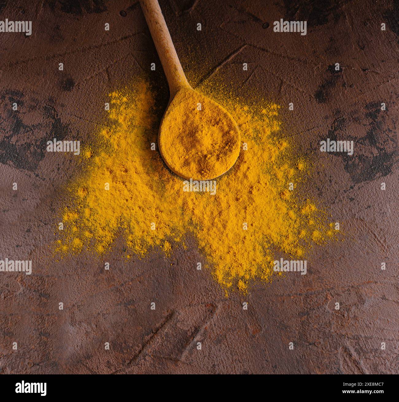 Yellow curry spice with wooden spoon Stock Photo