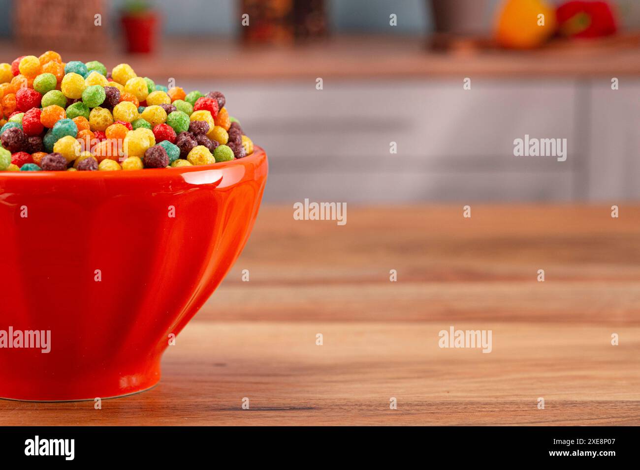 A Bowl of Small Ball Fruit Flavored Breakfast Cereal on a Wooden Kitchen Table Stock Photo