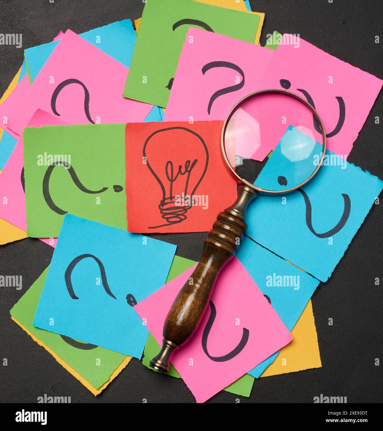 Drawn light bulbs on sheets of paper and a magnifying glass Stock Photo