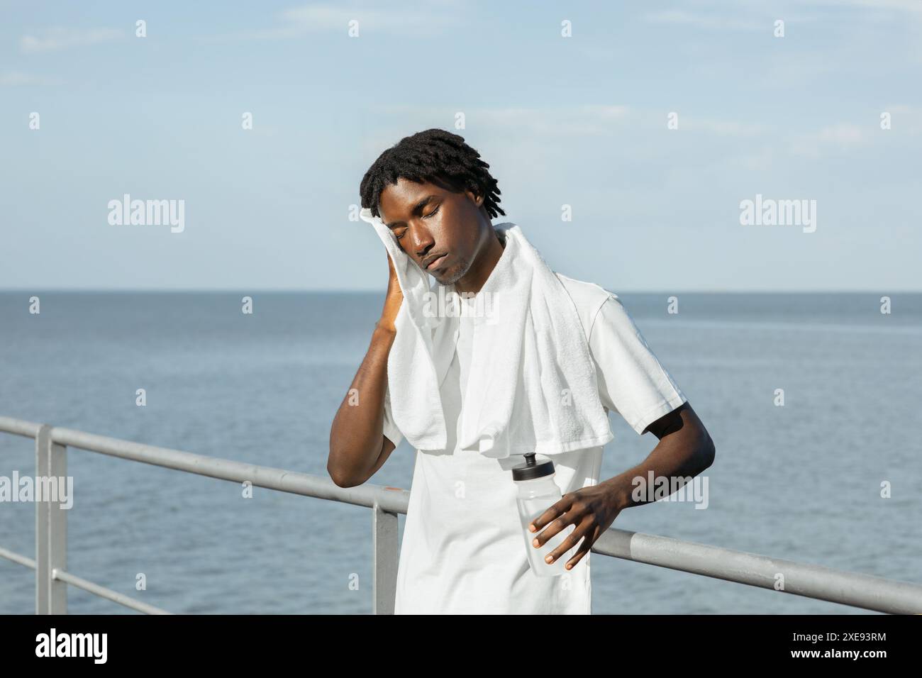 Resting On Railing Tired Athlete Resting on Railing After Workout By the Ocean Stock Photo ...