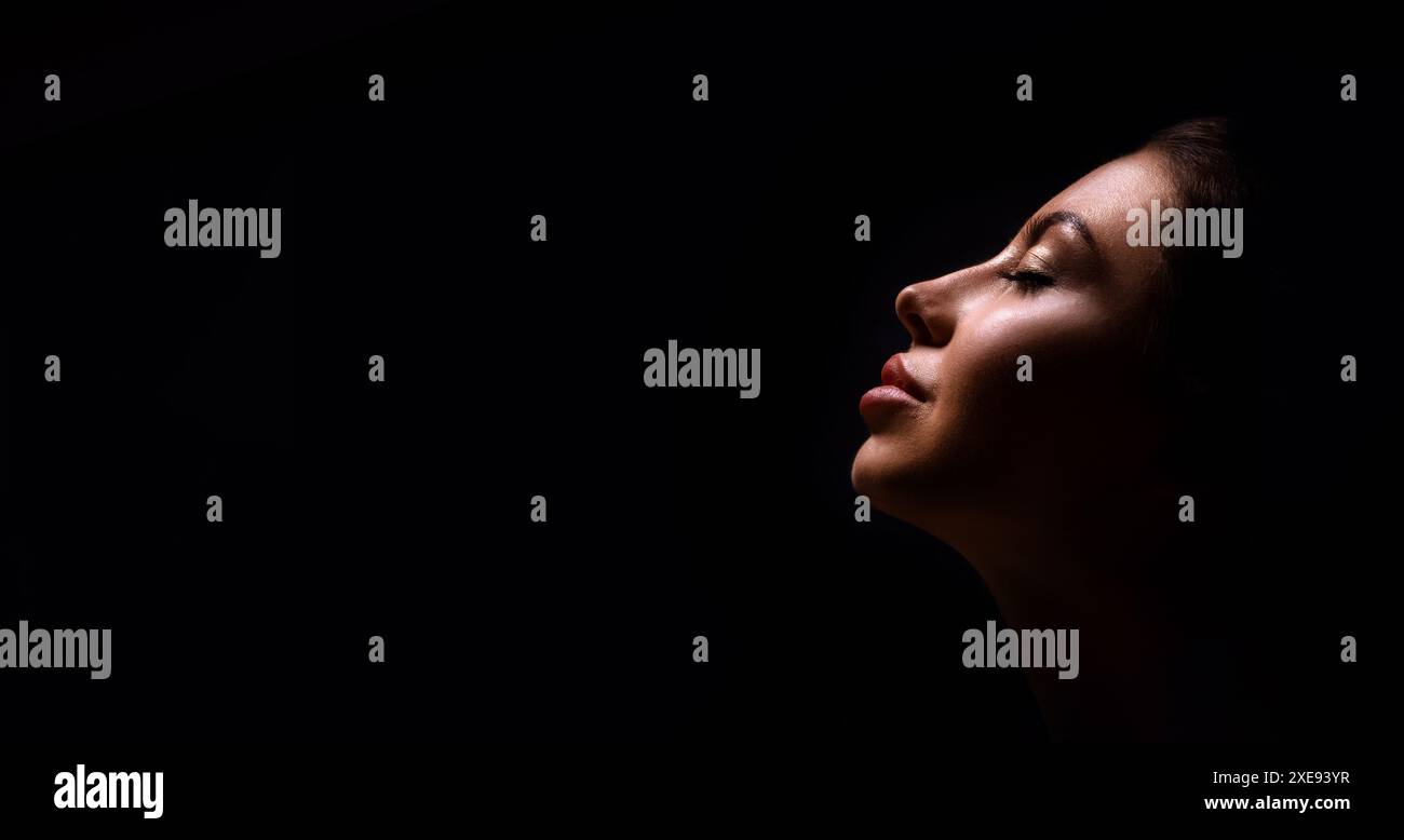 Closeup Profile Of Woman With Eyes Closed Against Dark Background Stock ...