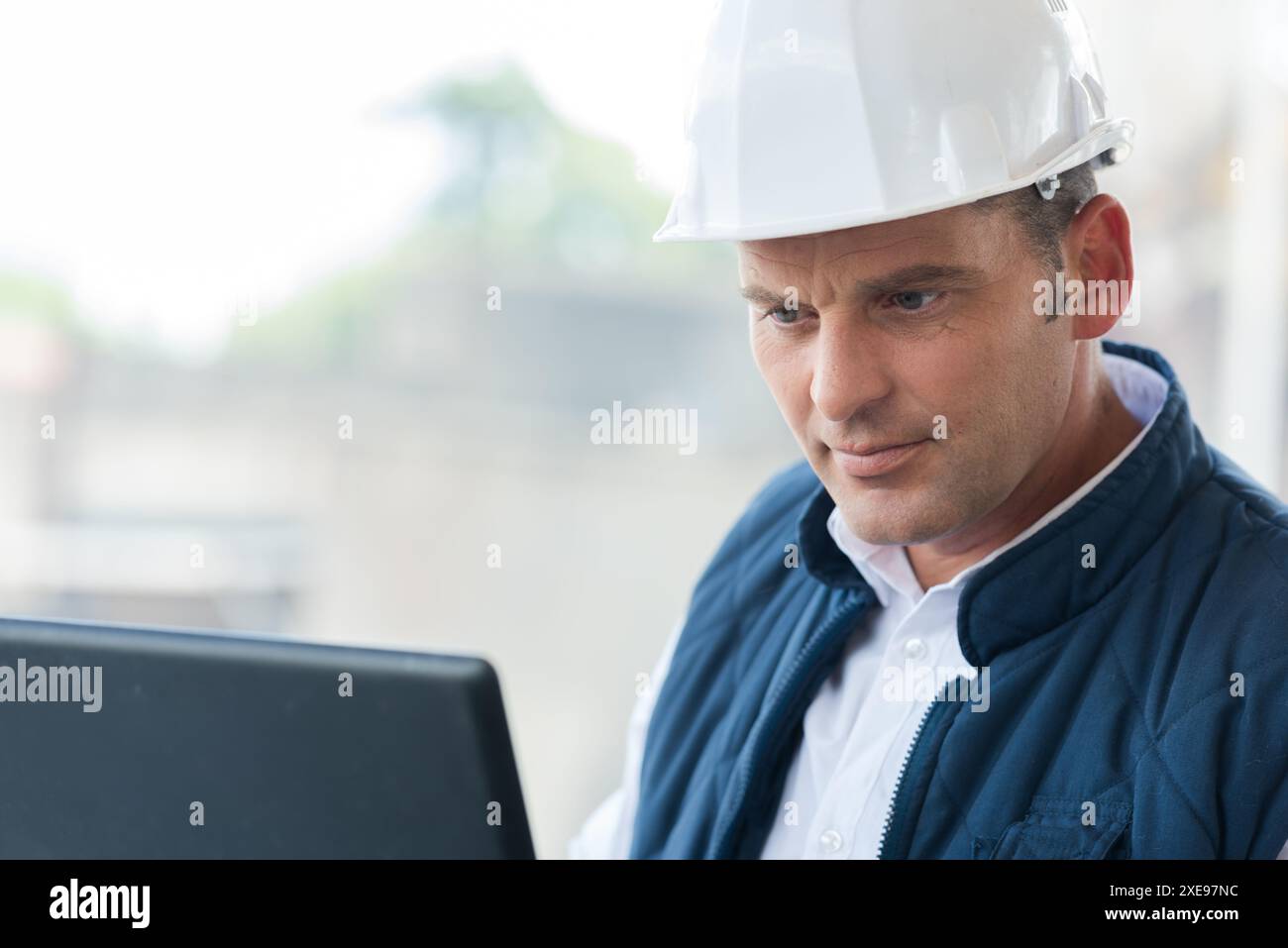 male engineer managing process with laptop Stock Photo