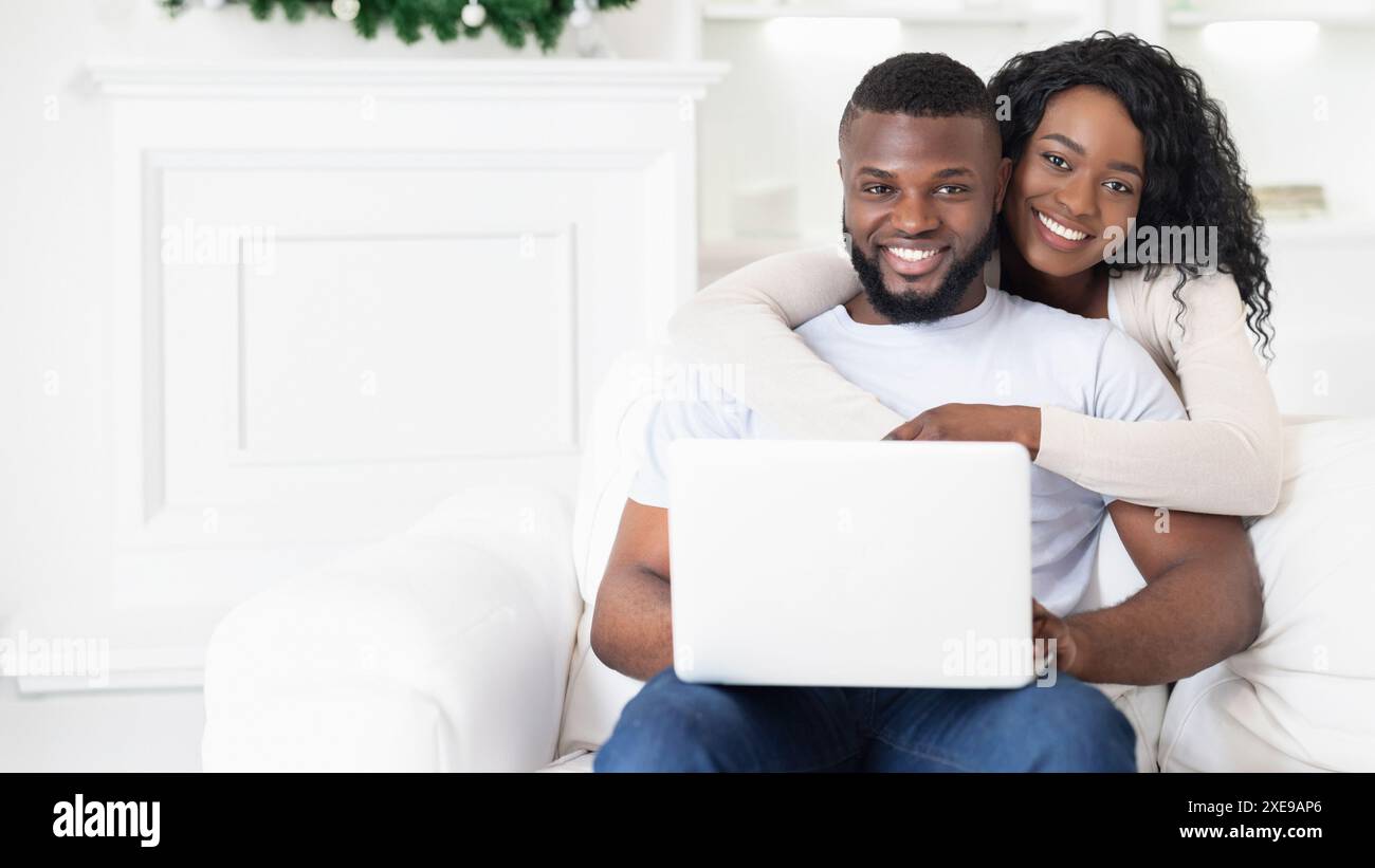 Couple Using Laptop on White Couch Stock Photo