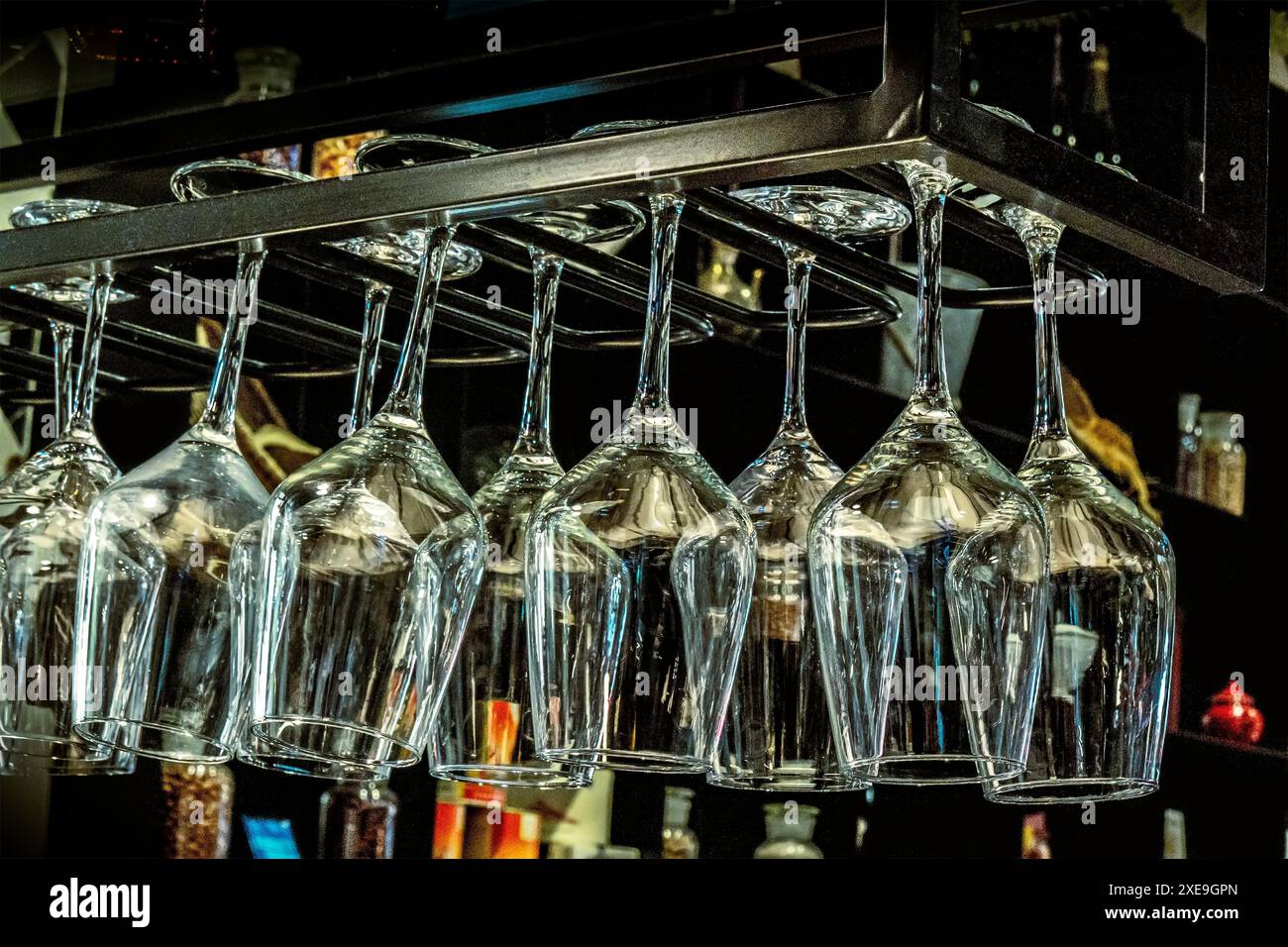 Wine glasses hanging from a stemware rack Stock Photo