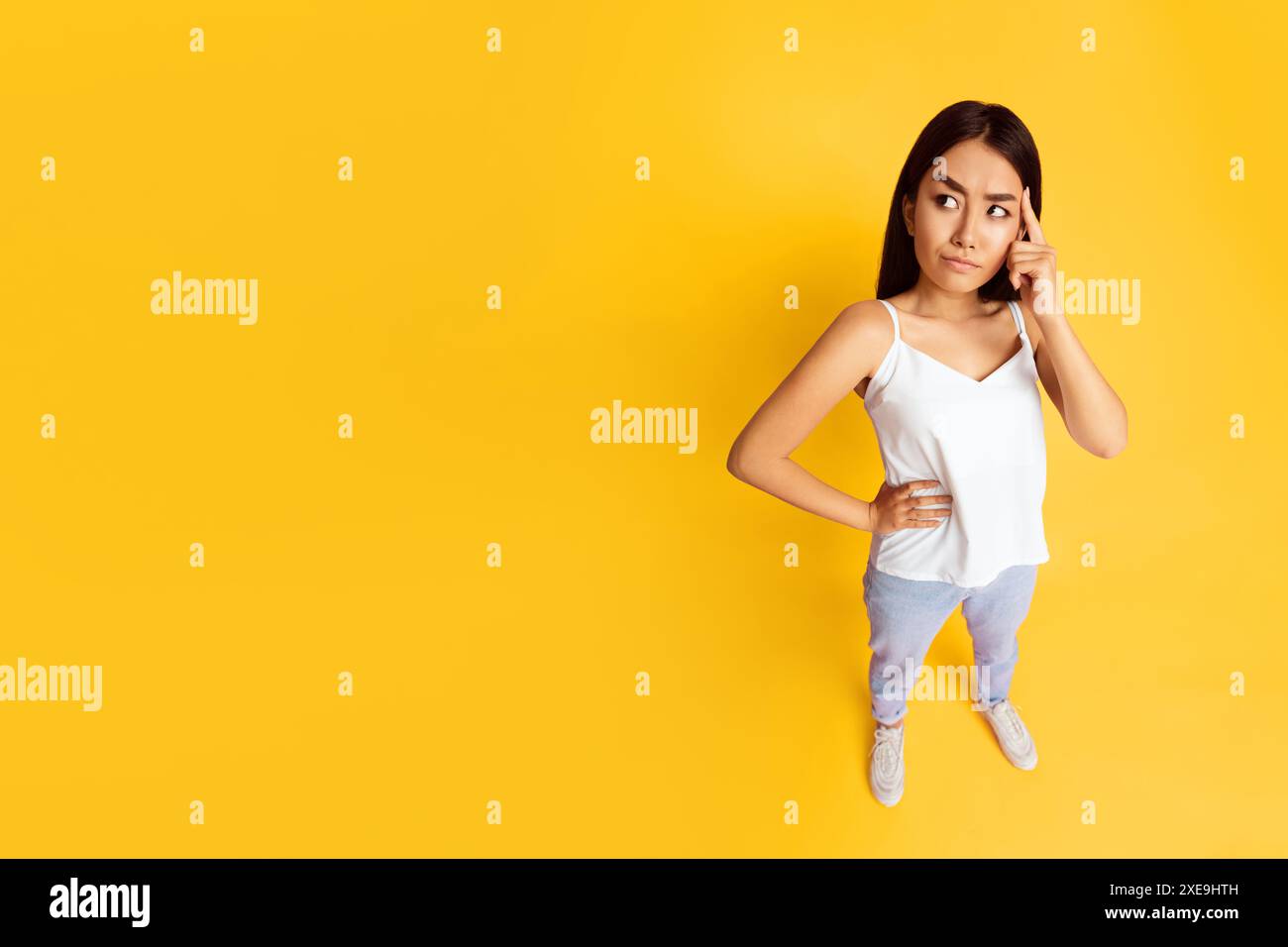 Young Asian Woman Thinking Against Yellow Background Stock Photo - Alamy