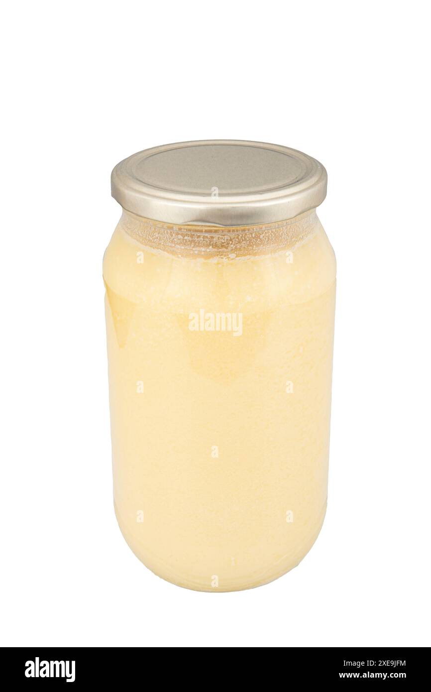 Ghee or clarified butter in jar isolated on white background. Clarified