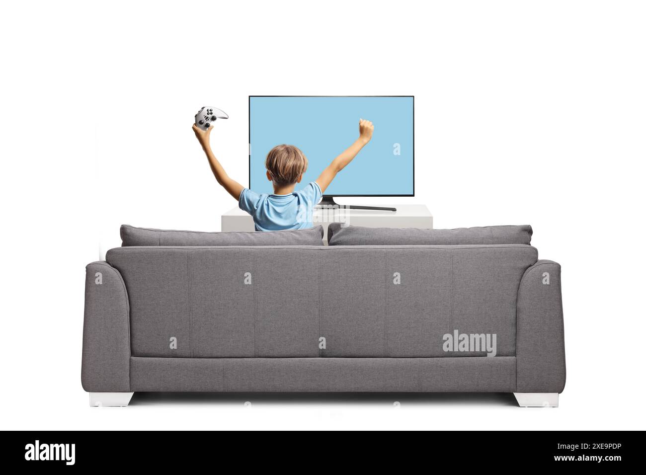 Rear view shot of a happy kid sitting on a sofa and playing a video ...
