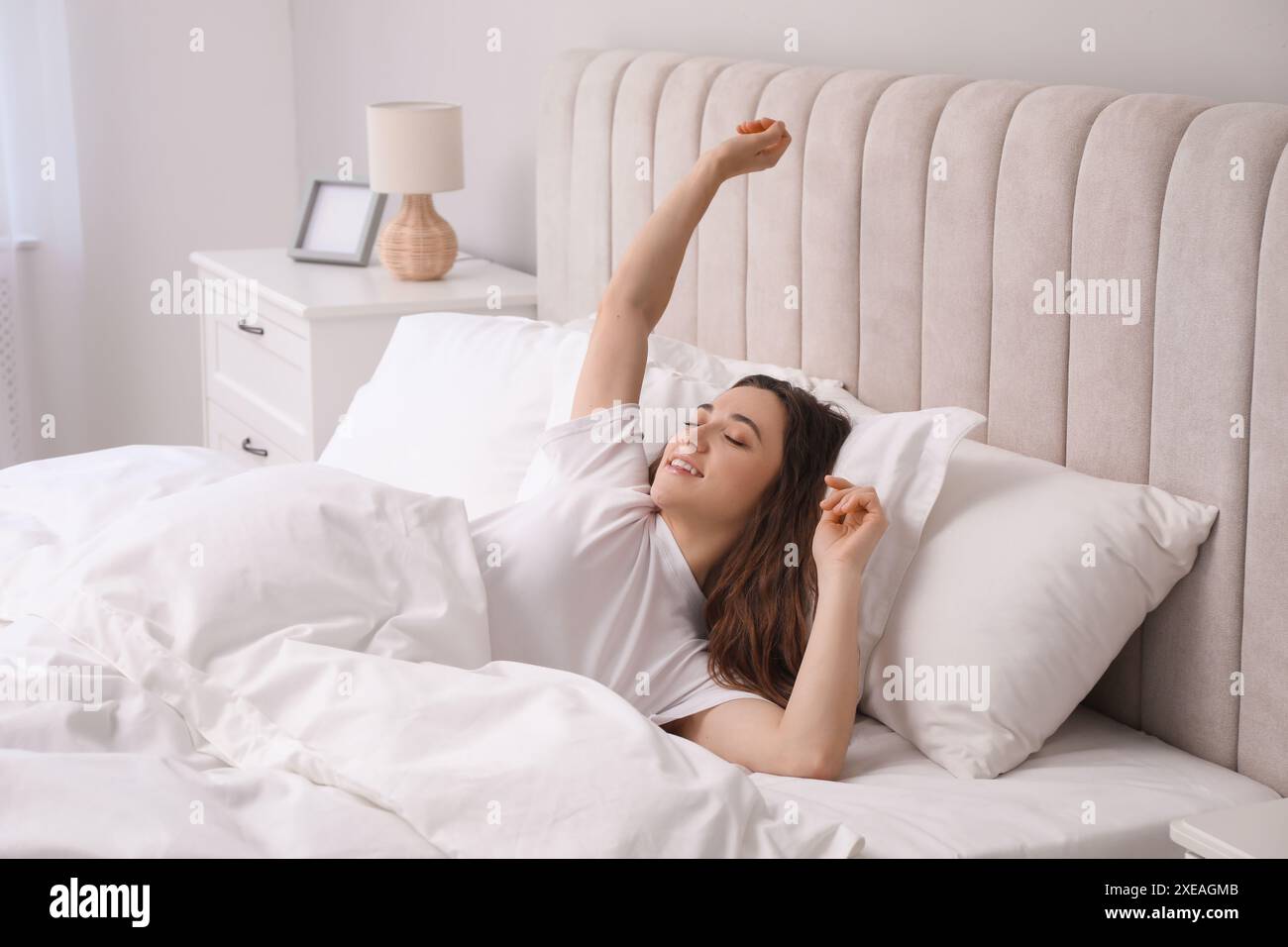 Happy woman lying in bed hi-res stock photography and images - Alamy