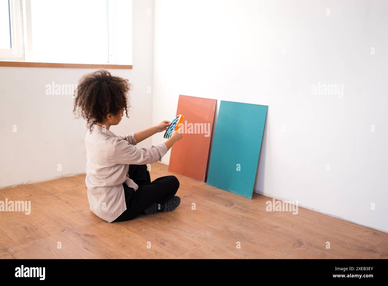African woman in casual clothes holds color palettes Stock Photo - Alamy