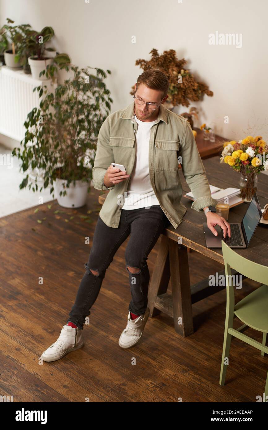 Portrait of a man in office, businessman making a phone call, having a conversation over the phone, receive a call, standing in Stock Photo