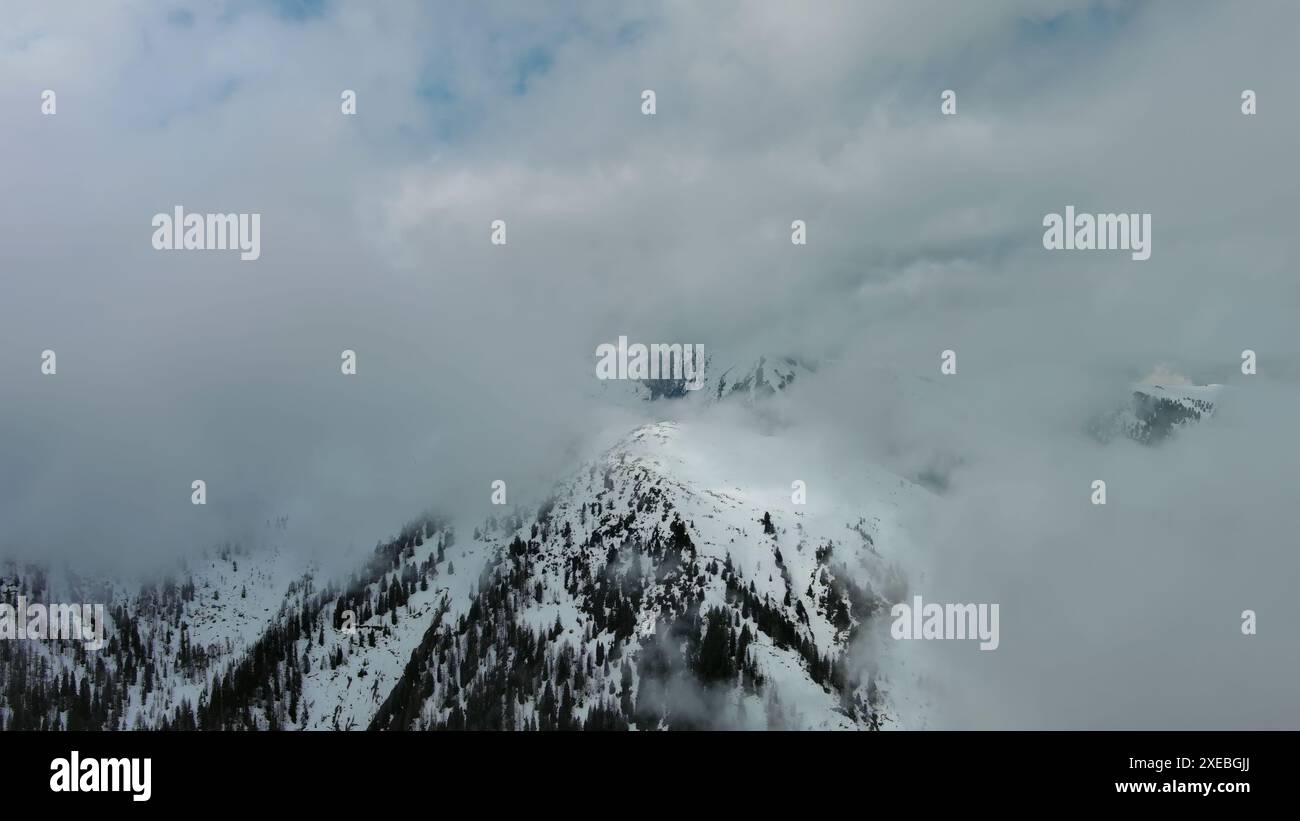 Aerial view of snowcapped mountains in clouds Stock Photo - Alamy