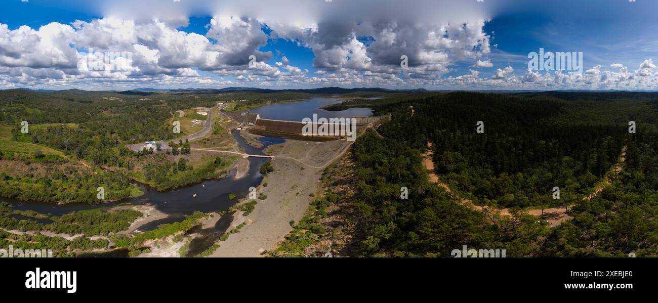 Aerial view of Paradise Dam on the Burnett River surrounded by a hoop pine forest under a cloudy sky Stock Photo