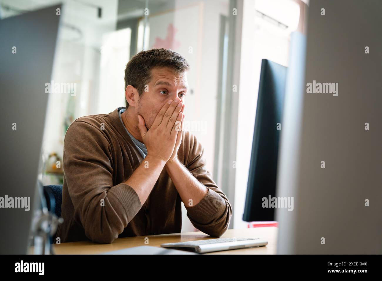 Portrait of a disappointed man programmer looking stressed out while working on a computer code Stock Photo