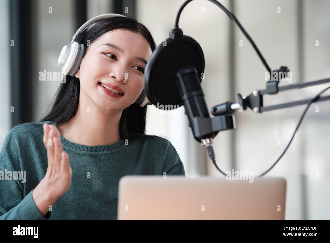 A woman wearing headphones and smiling at the camera Stock Photo - Alamy