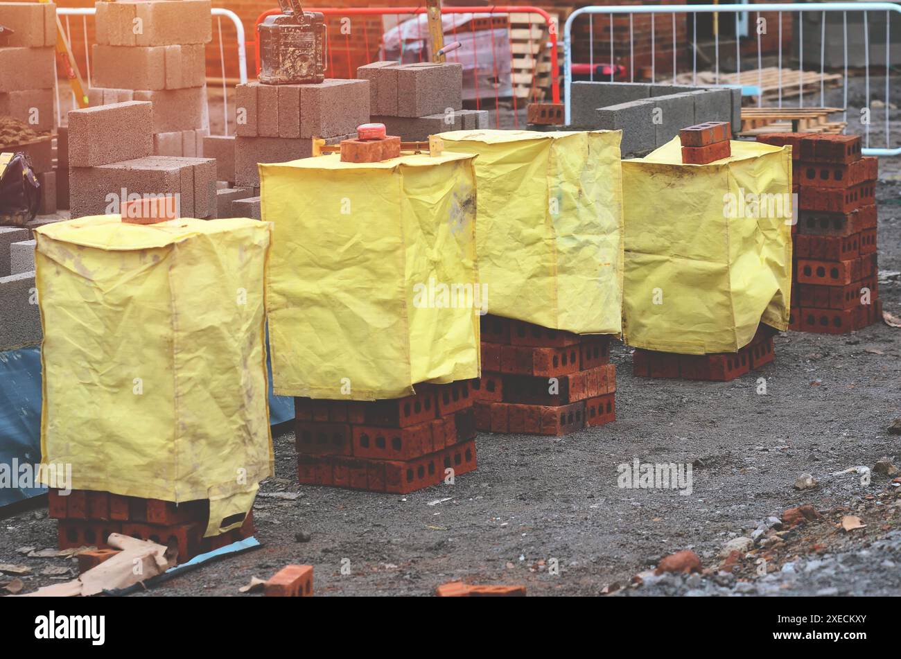 Red bricks and concrete blocks delivered on construction site and placed next to place of work ready for bricklayers Stock Photo
