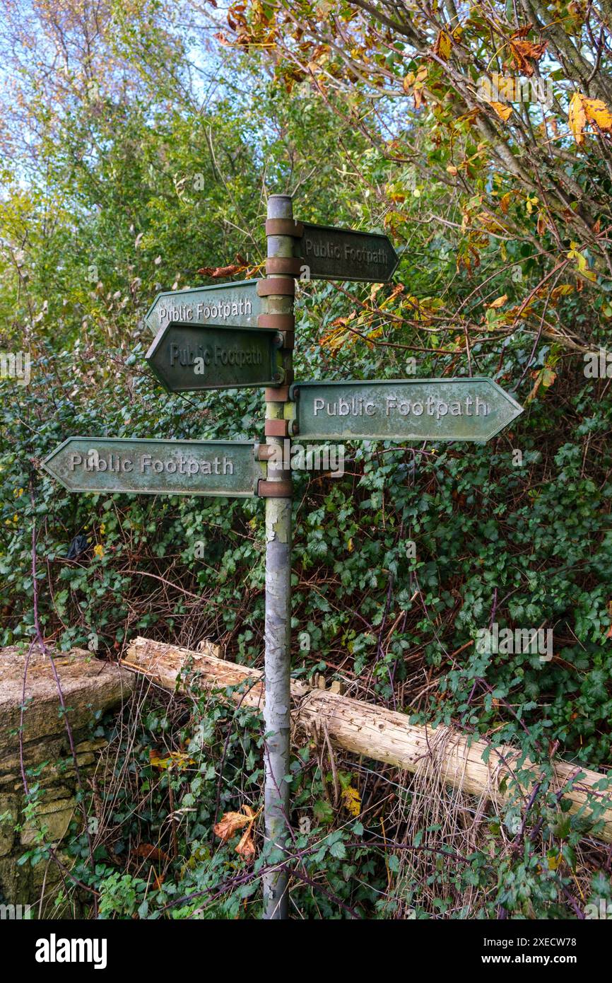 Old and weathered metal footpath sign in the countryside with multiple ...