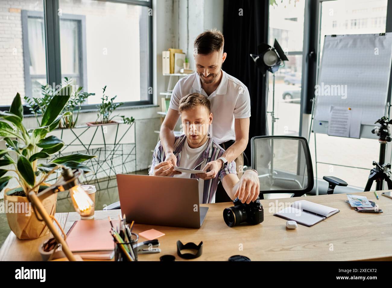 Two loving men engrossed in laptop screen. Stock Photo