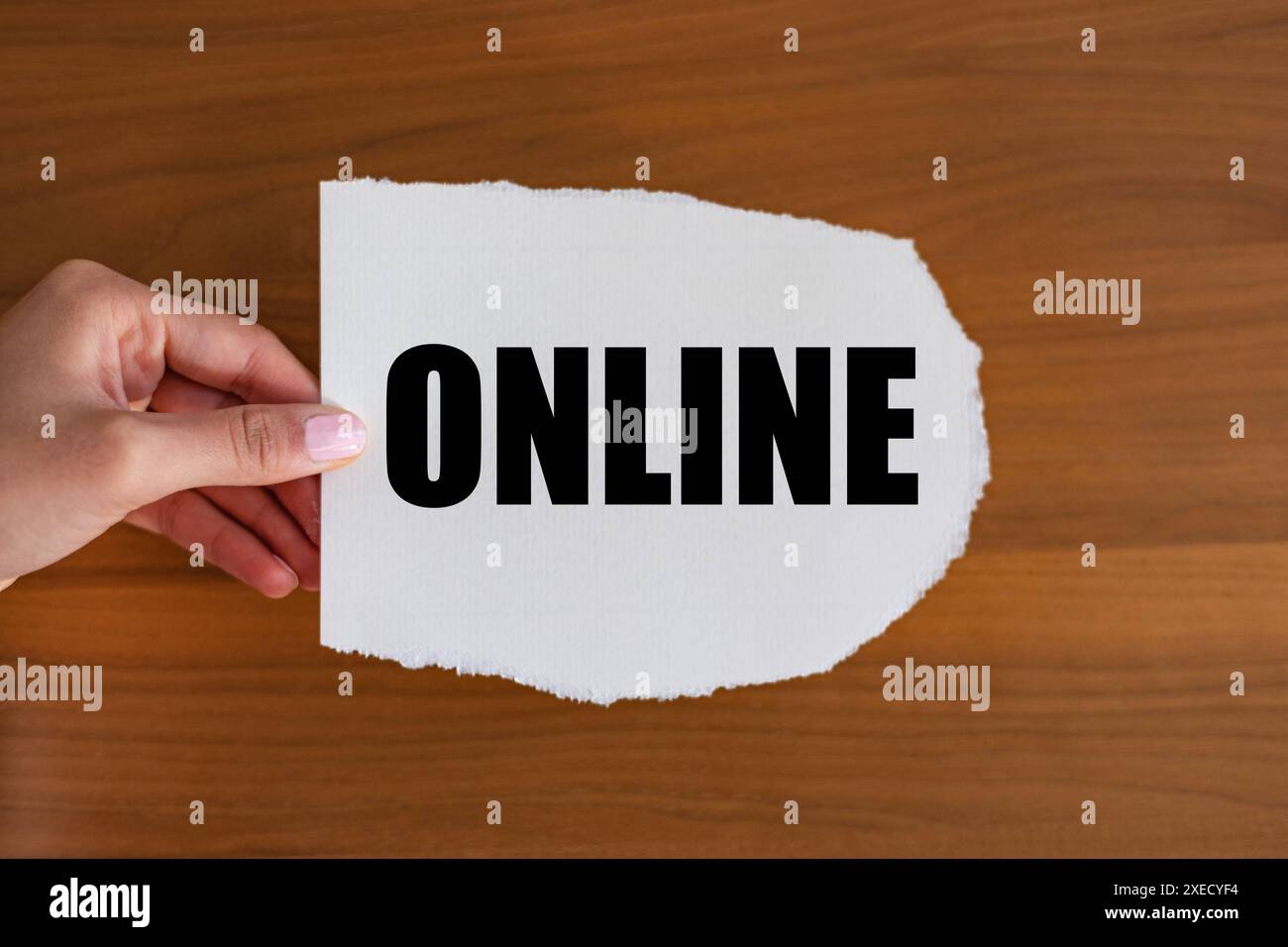 Online Online. Woman hand holds a piece of paper with a note, online. Social media, internet, blogging, e-commerce, influencer. note_B1983_online Stock Photo