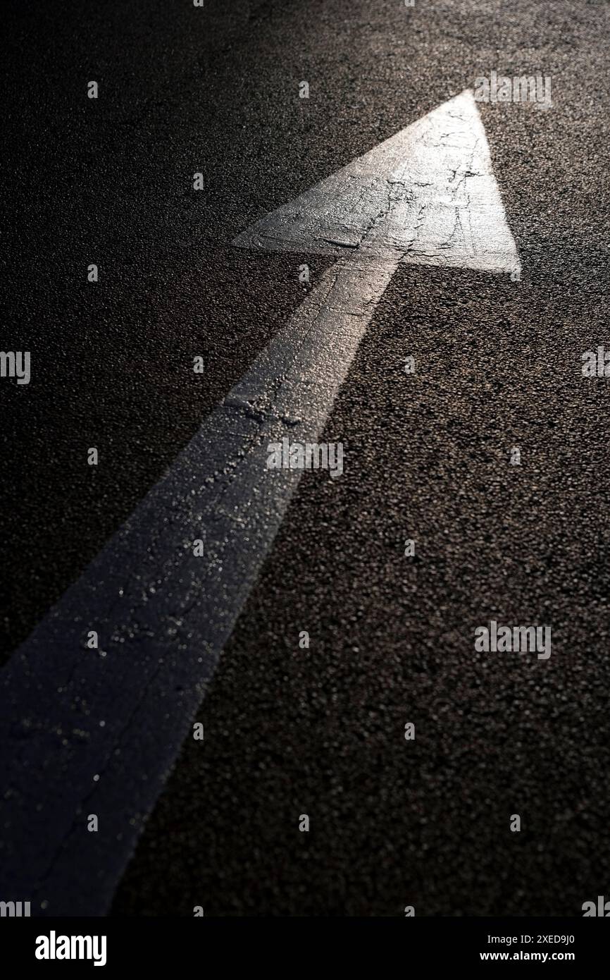 Asphalt road in bright sunshine with white painted arrow Stock Photo ...
