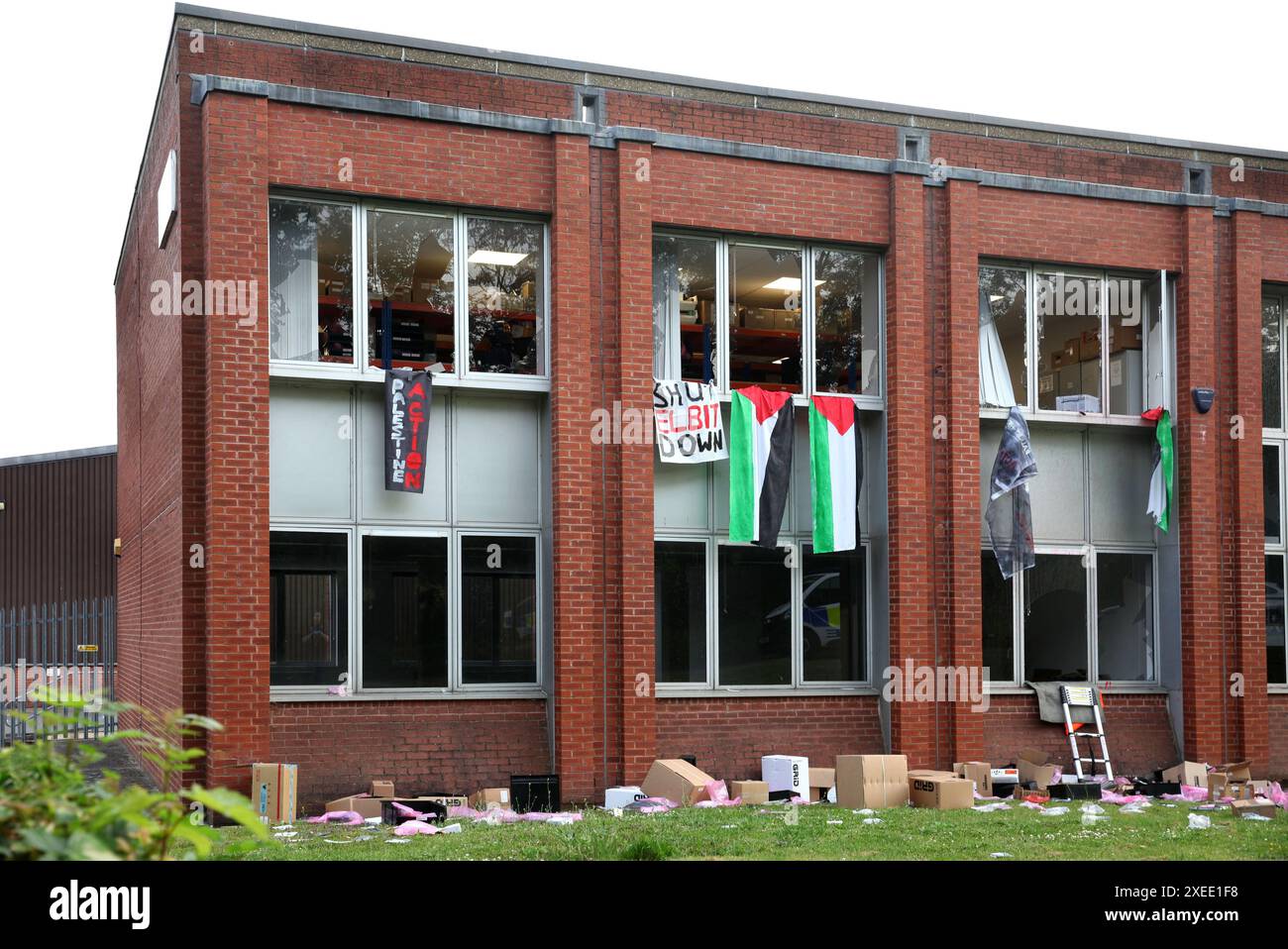 High Wycombe, England, UK. 27th June, 2024. Grid's offices stand damaged piles of their property on the lawn below, with banners and Palestinian flags hanging from the broken windows after activists gained access overnight and caused damage. Palestine Action activists as well as targeting Elbit Systems they been targeting partner companies of the Israeli arms company and those that invest in the company, by using repeated direct action to disrupt and isolate Elbit. A number of companies in the last year have broken off all ties with the weapons manufacturer. Grid Defence Systems pr Stock Photo