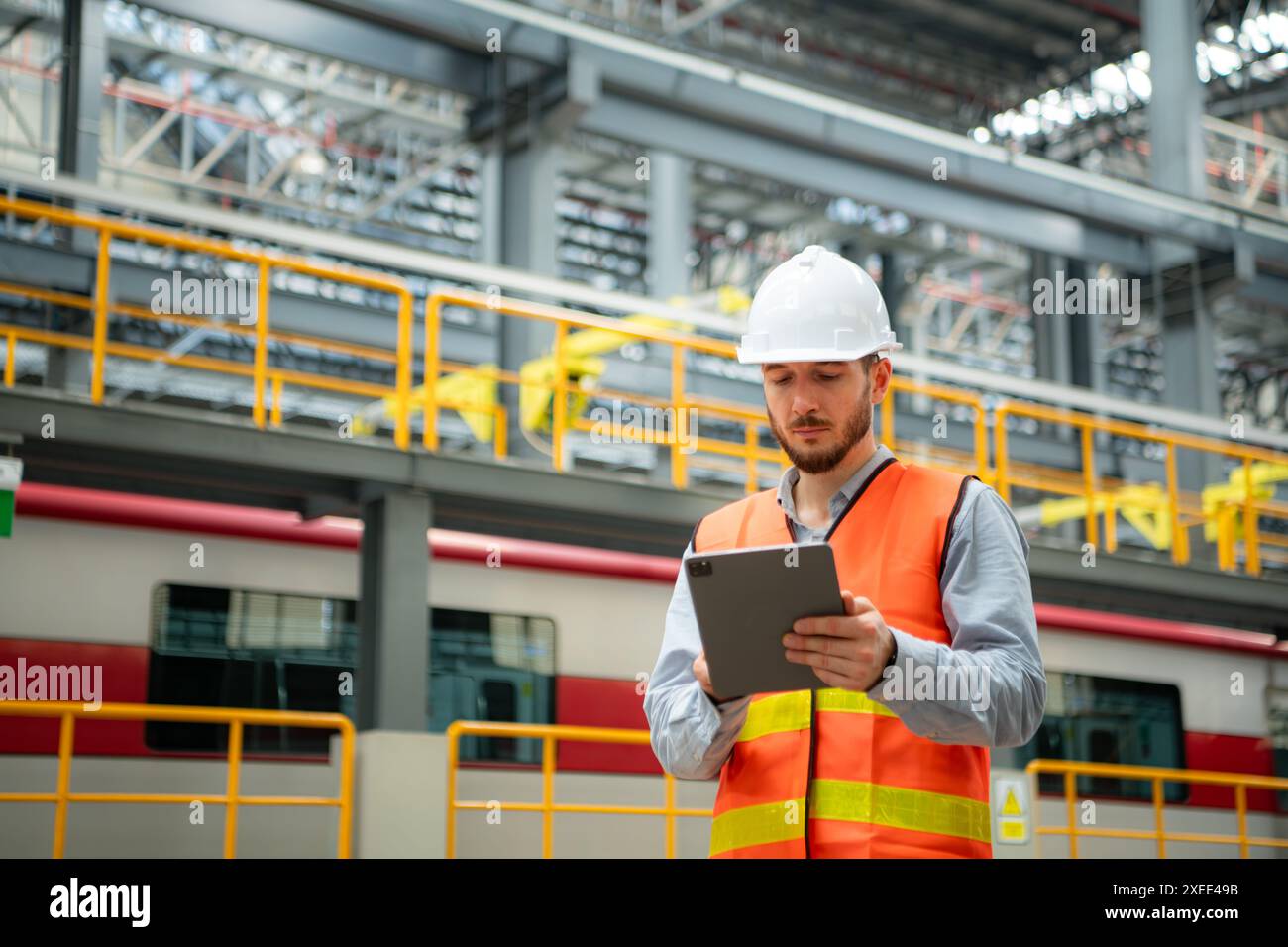 Portrait of a young male technician using a walkie talkie working and standing in a skytrain repair station. Stock Photo