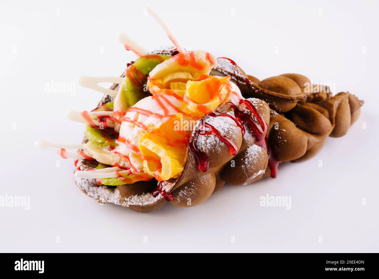 Egg waffle with ice cream and fruits with syrup Stock Photo - Alamy