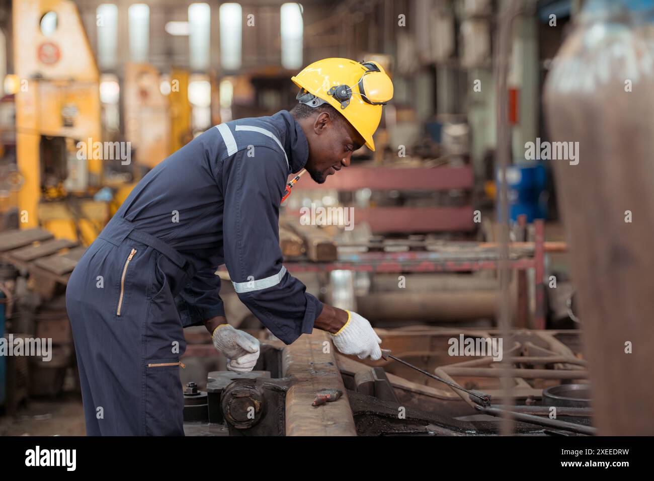 Railway technician in uniform and safety helmet working on train repair station Stock Photo