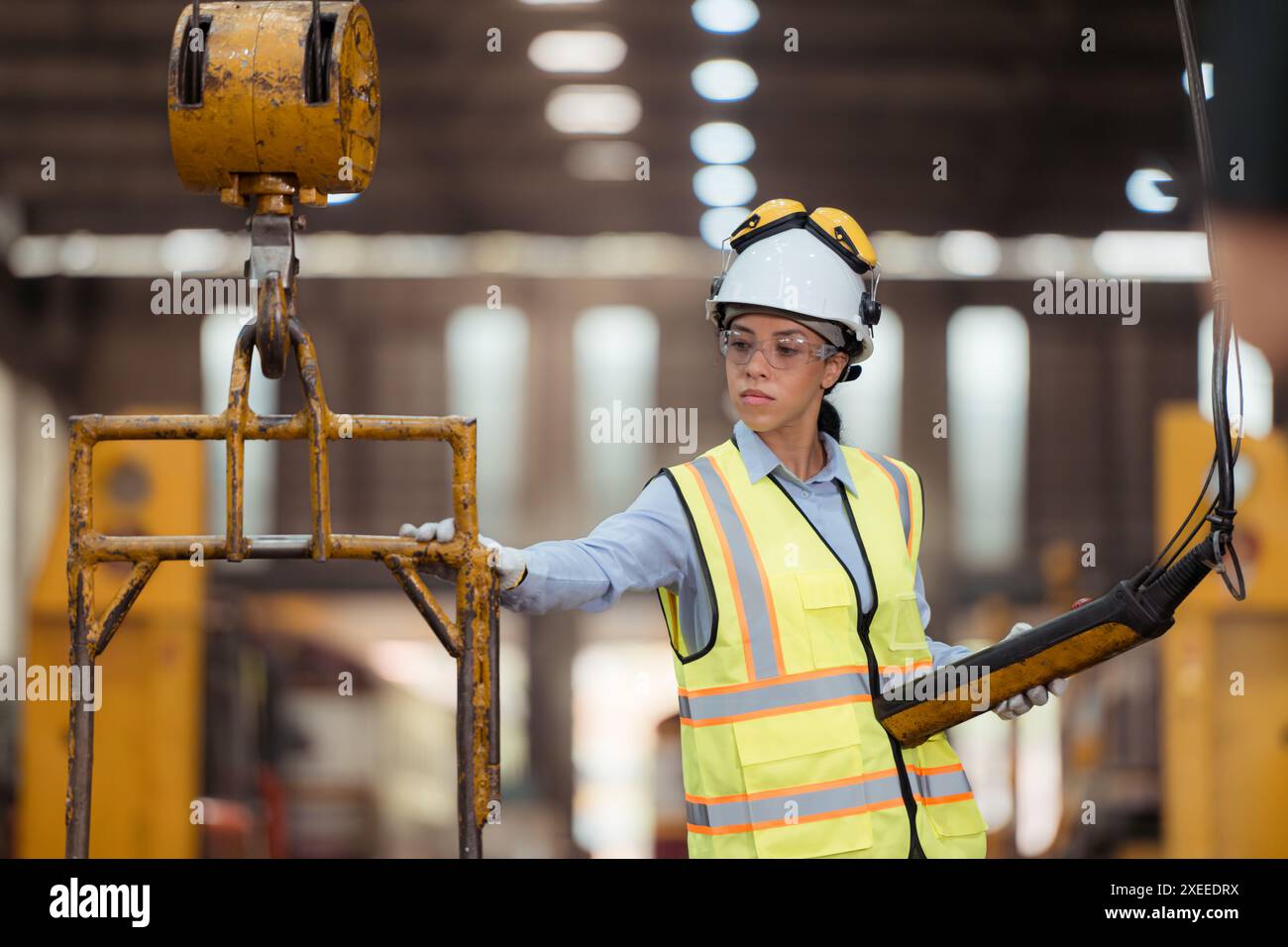 Portrait of railway technician worker in safety vest and helmet working at train repair station Stock Photo