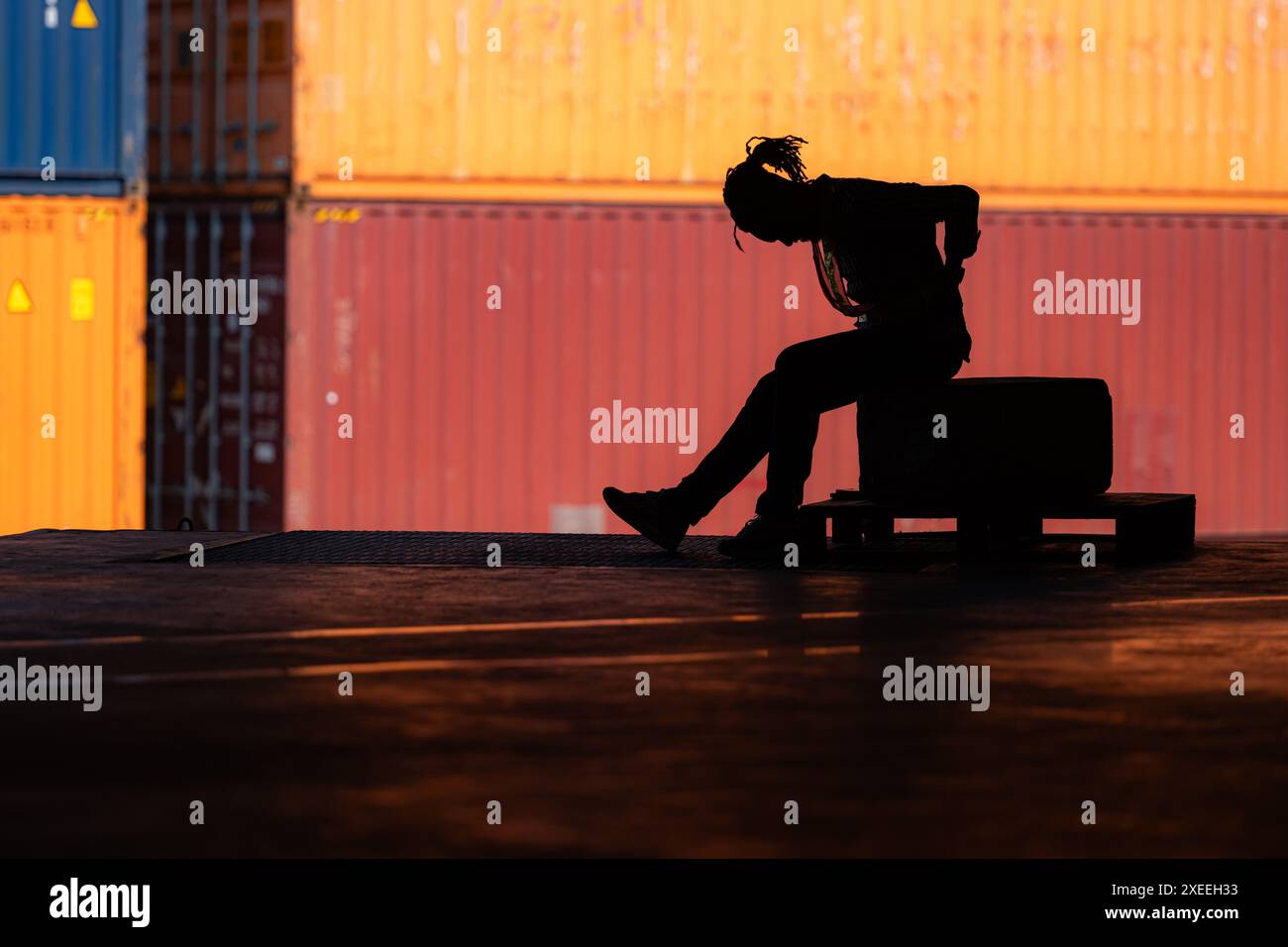 Warehouse worker's back pain from hard work while sitting and relaxing, Silhouette concept Stock Photo