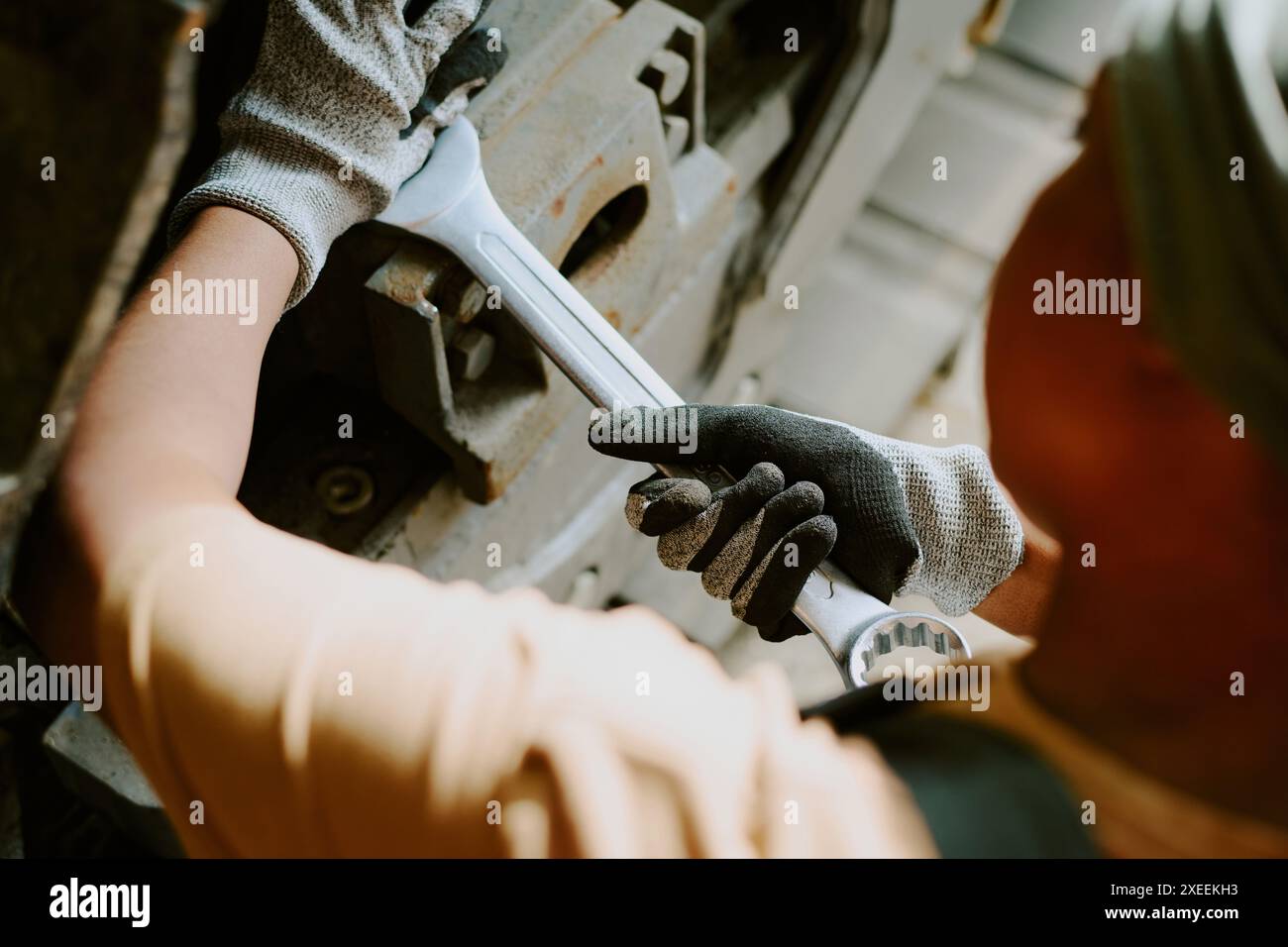 Person Using Wrench High angle view of unrecognizable Black female mechanic using wrench to ...