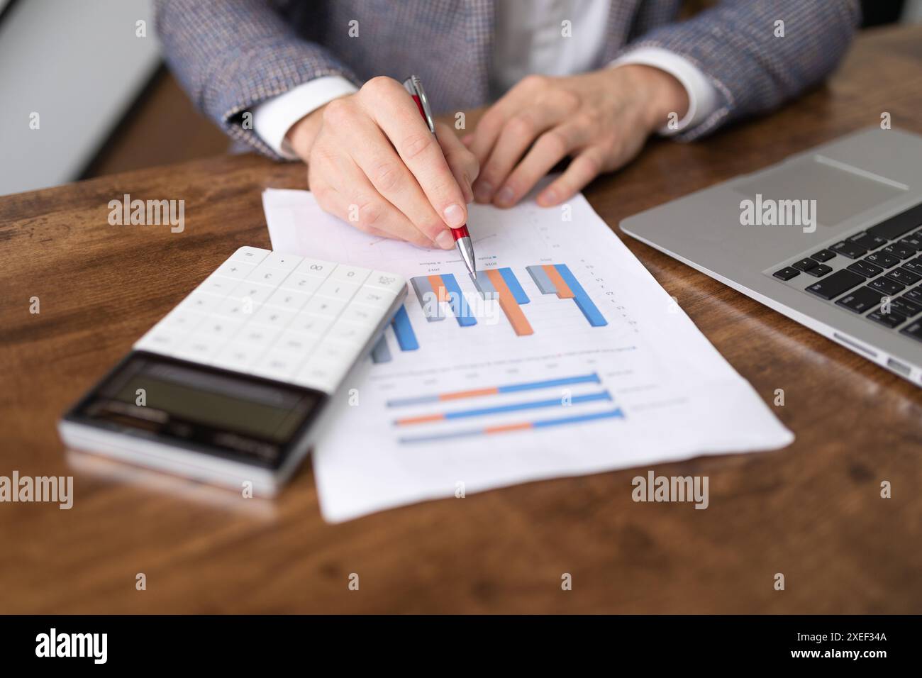 Financial analyst with diagrams of the affairs of the company notes the successes on the sheets Stock Photo