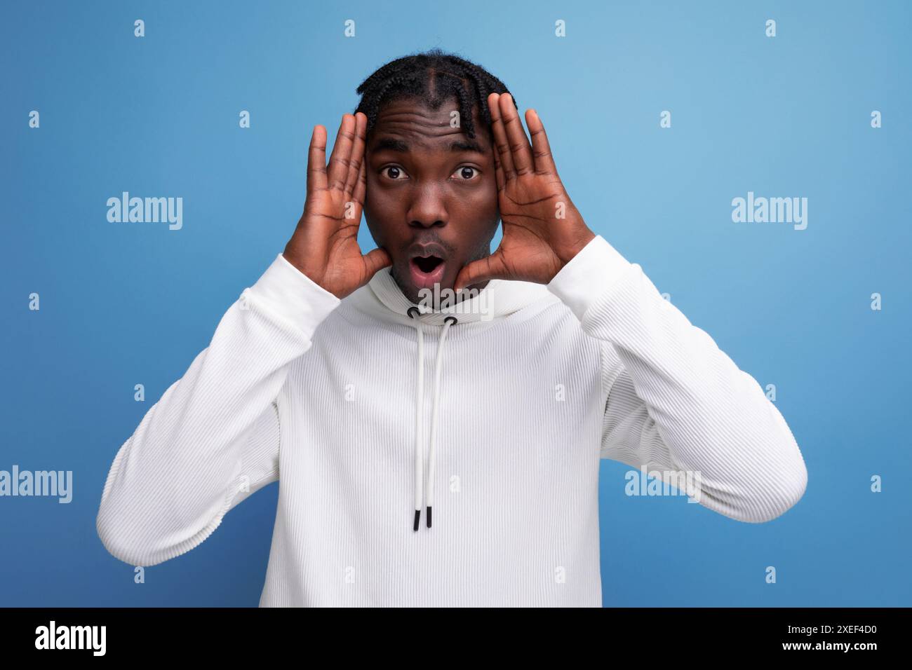 Energetic dark-skinned young brunette male tries to scare Stock Photo