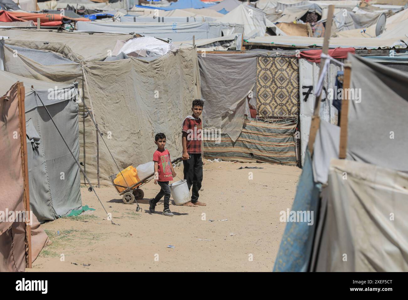 Displaced Palestinian children are walking in front of their makeshift ...