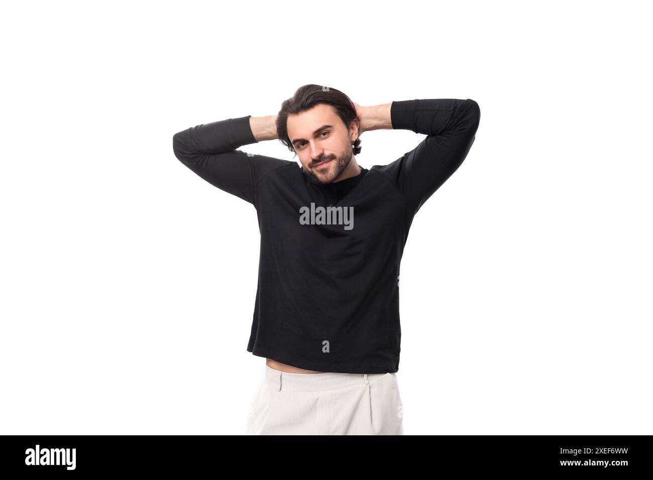 Young bearded brutal european macho man with ear piercing and with black hair on isolated white background with copy space Stock Photo