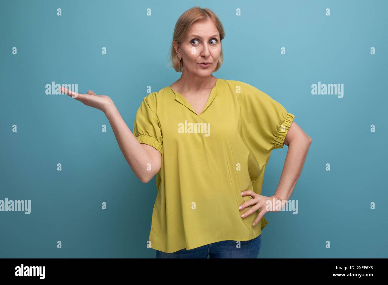 Middle aged woman with insight points finger to the side in studio Stock Photo