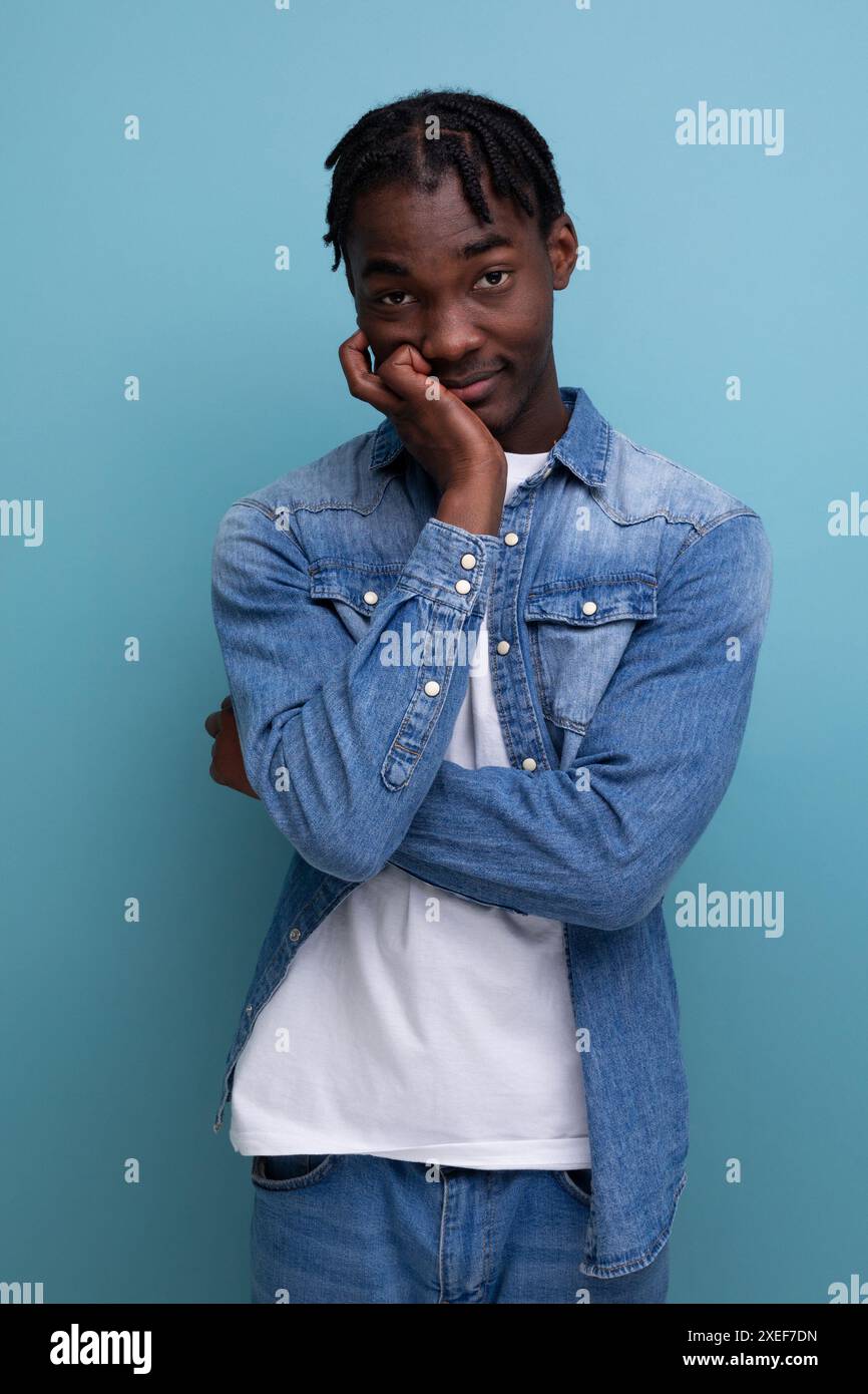 Portrait of a shy young african man with dreadlocks in a denim jacket posing thoughtfully Stock Photo