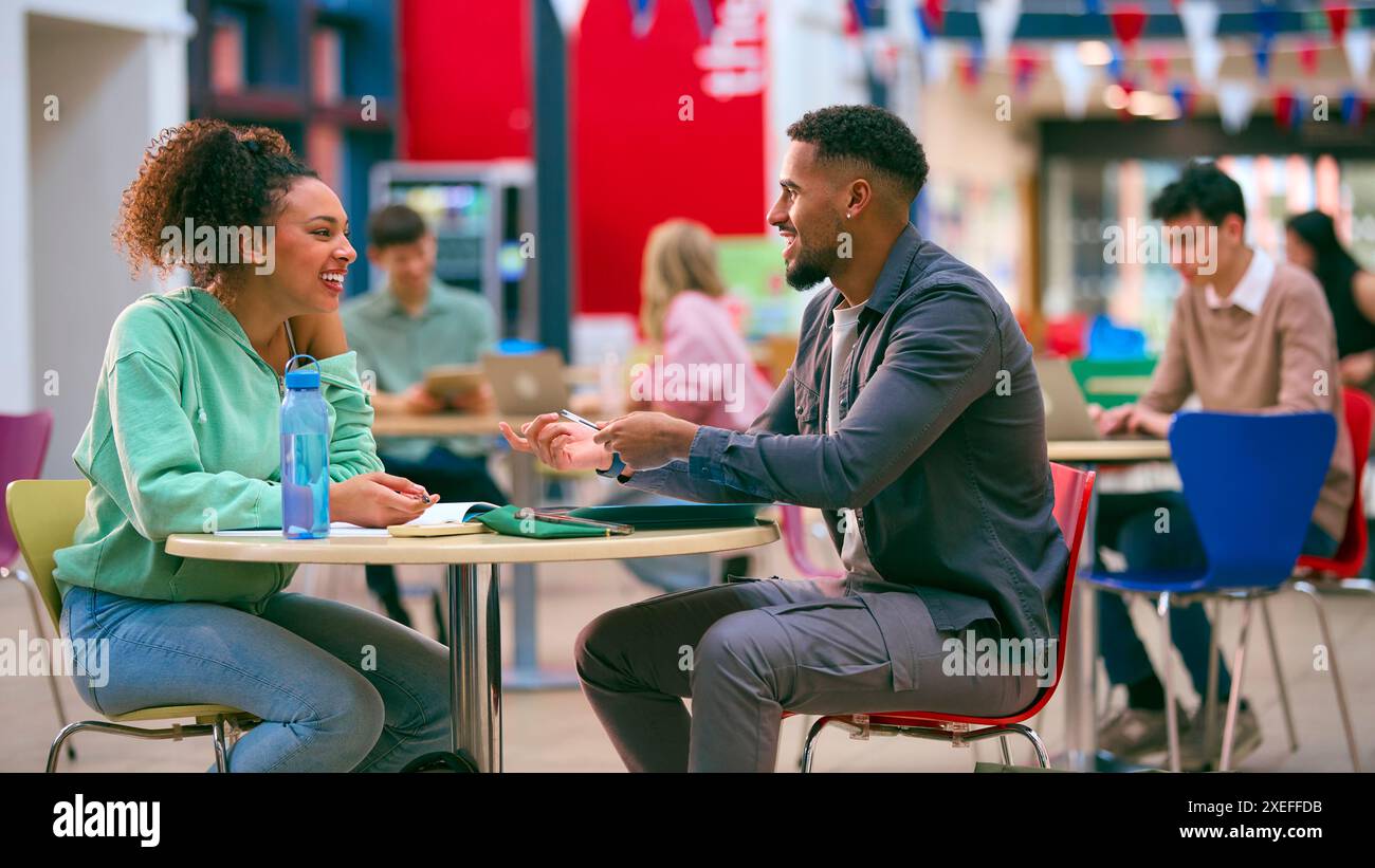 Male And Female College Or University Students Working Together At Table In Study Area Stock Photo