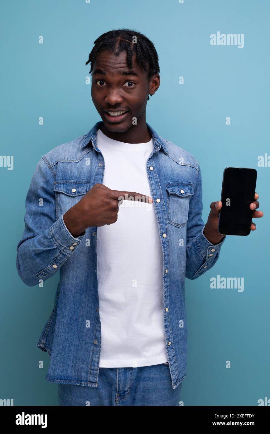 Smiling african man with black dreadlocks using smartphone Stock Photo