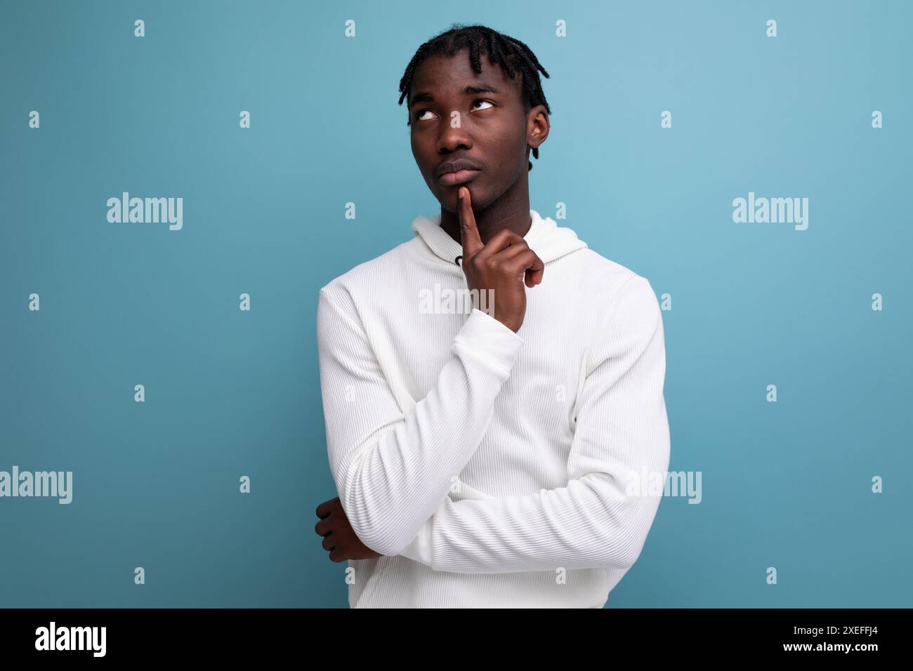 Smart dark-skinned young brunette man solves a problem in his head Stock Photo