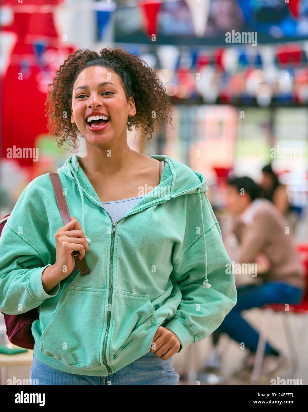 Portrait Of Smiling Female University Student Standing Inside College Building Stock Photo