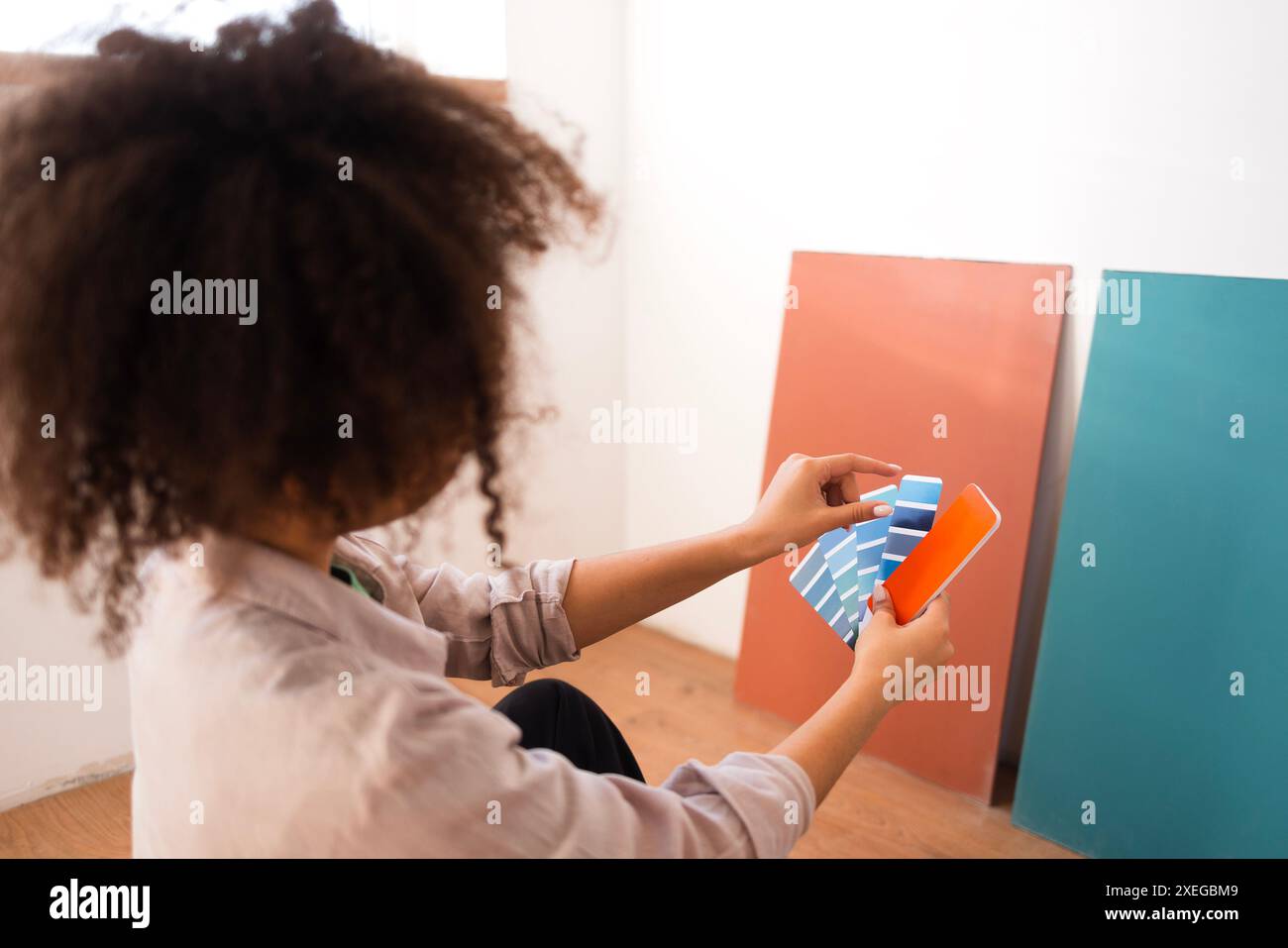 Attractive African woman in casual clothes holds palette of shades of ...
