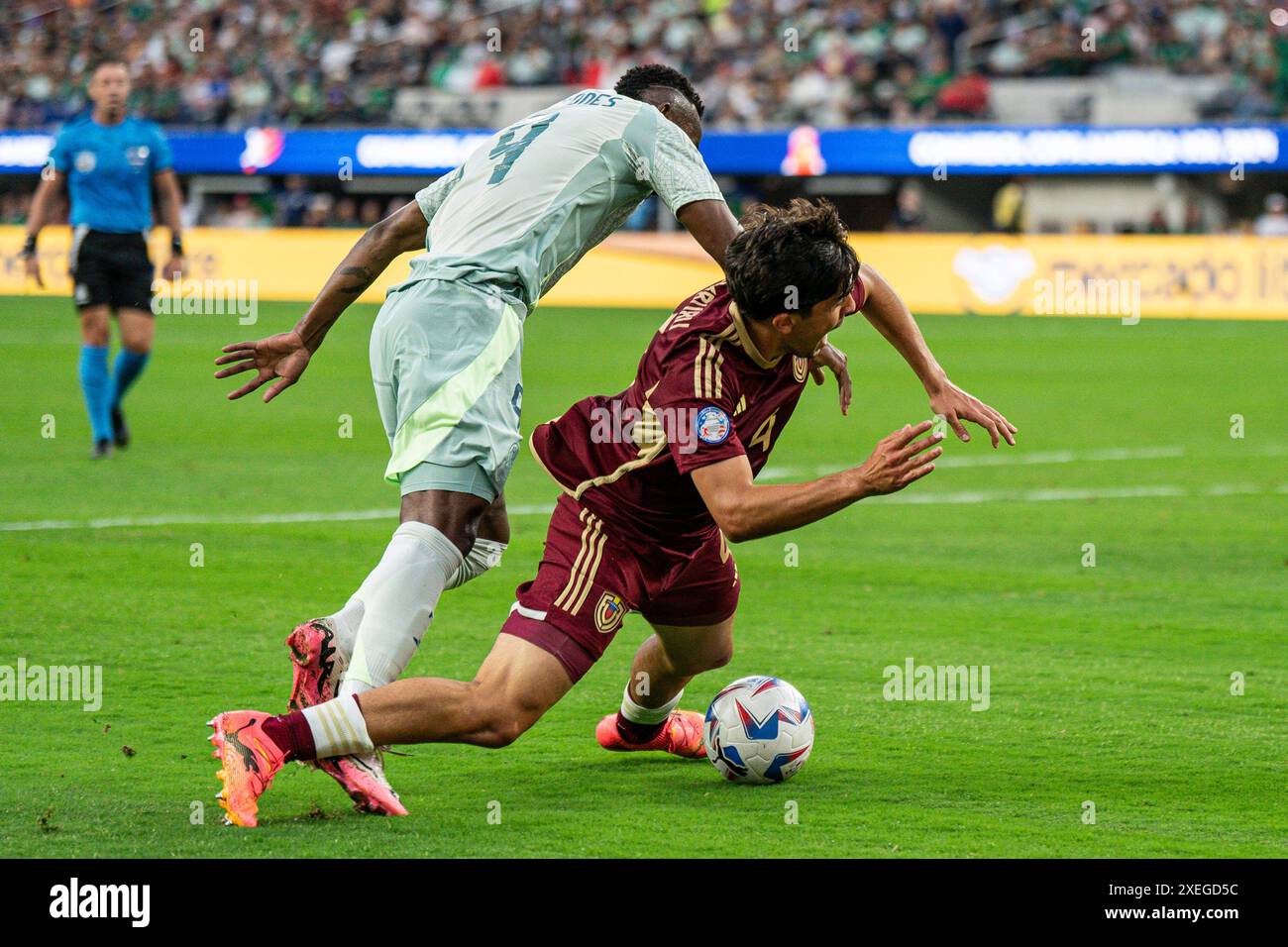 Mexico forward Julian Quiñones (9) fouls Venezuela defender Jon Mikel Aramburu (4) for a penalty during the Copa América group stage, Wednesday, June Stock Photo