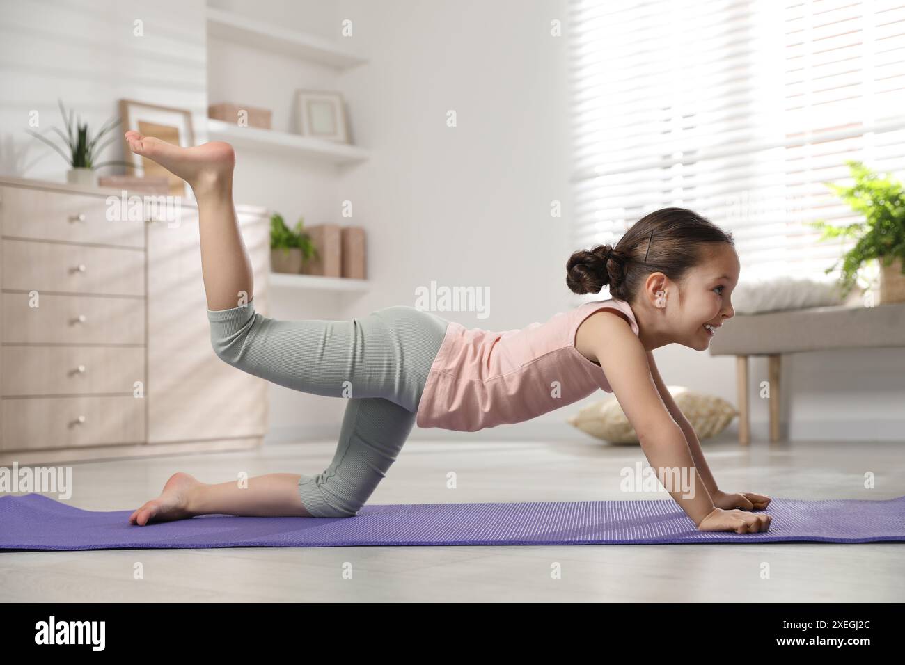Cute little girl doing exercise at home Stock Photo - Alamy