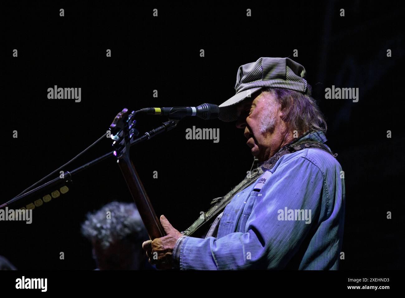 Neil Young on stage singing and playing guitar Stock Photo