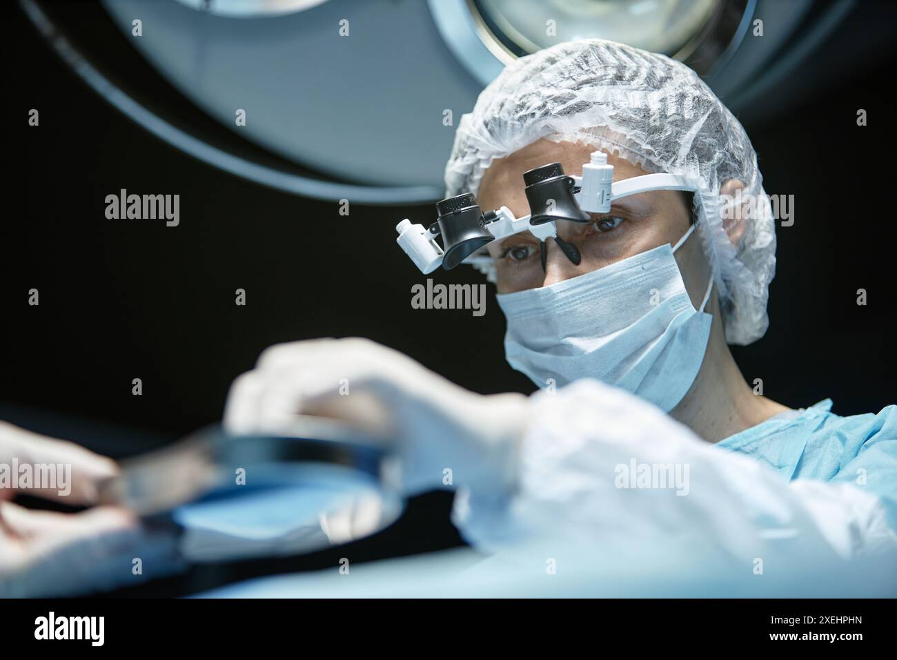Low angle view at mature female surgeon wearing mask and surgical ...