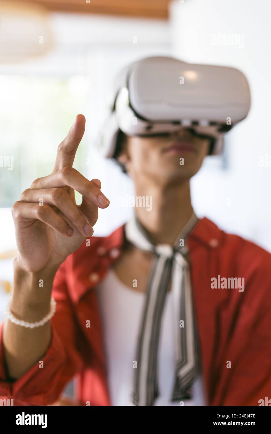 Using VR headset, young man interacting with virtual environment at home Stock Photo