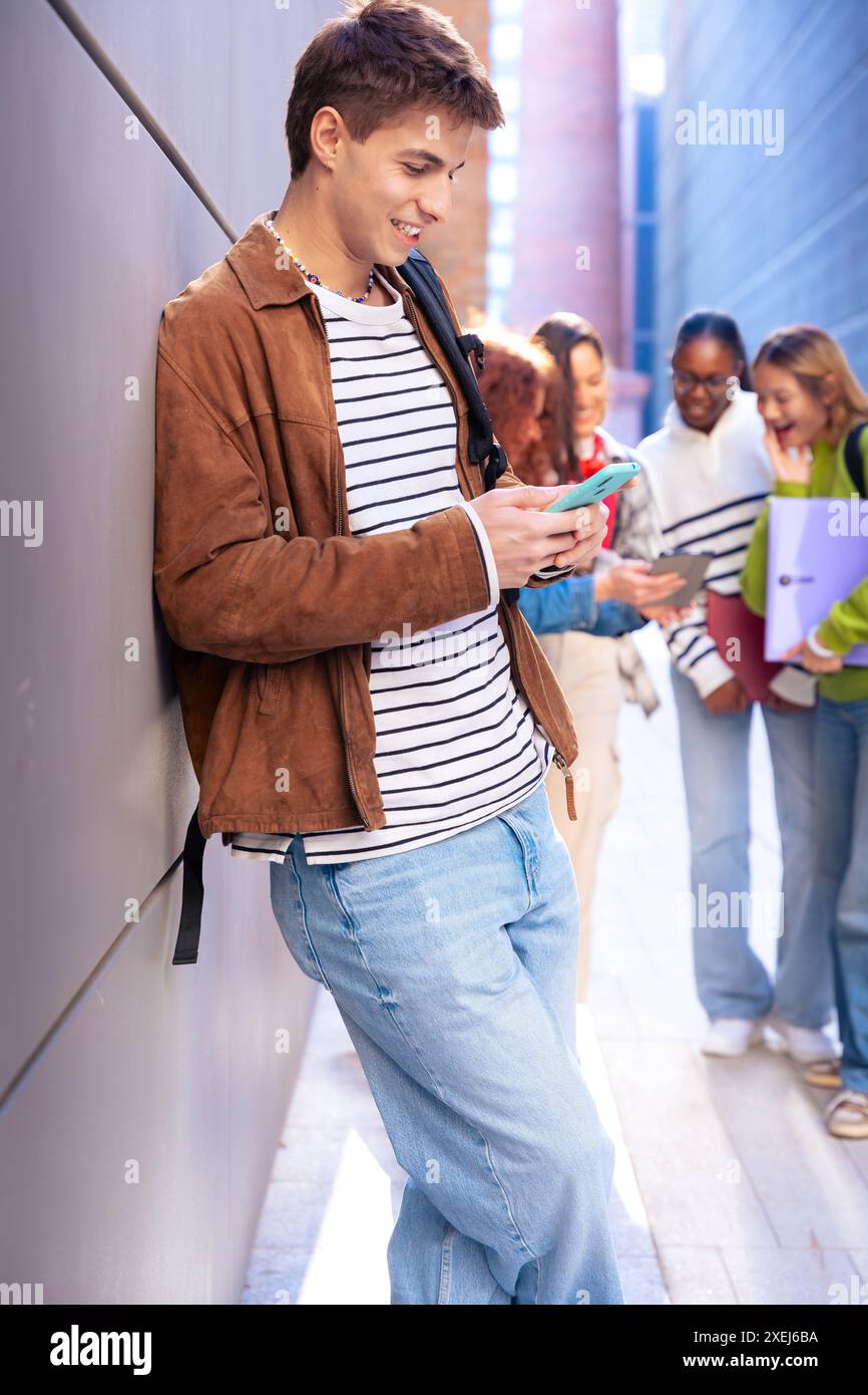 Young caucasian man browsing the internet using smartphone outdoors.Vertical Stock Photo