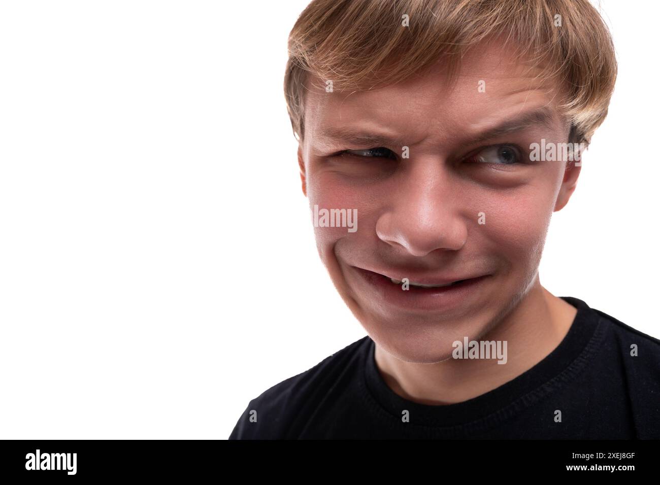 Funny teenage guy with blond hair makes a grimace Stock Photo